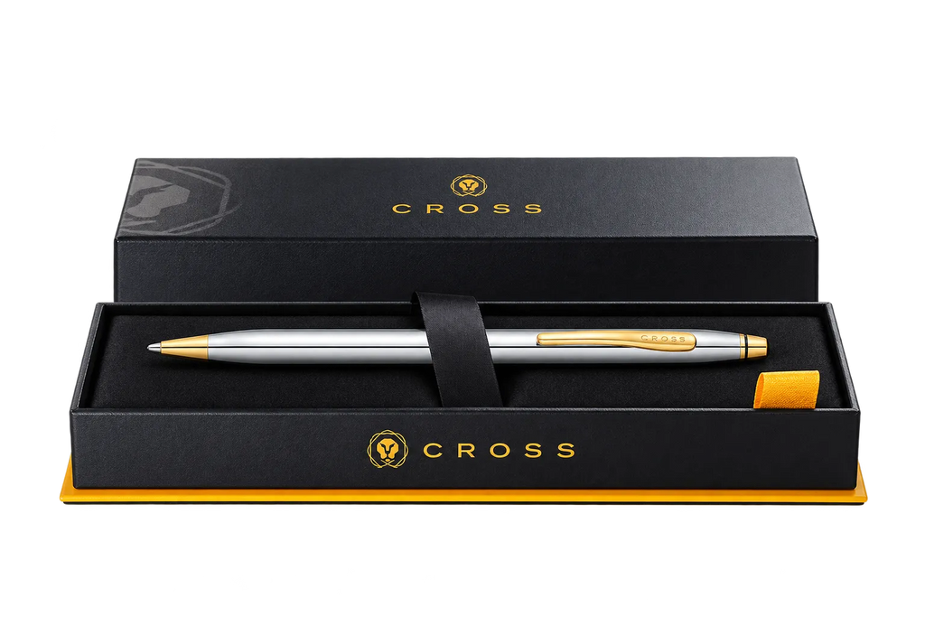 A silver and gold Cross pen presented in an open black gift box with a black strap, on a clean white background.