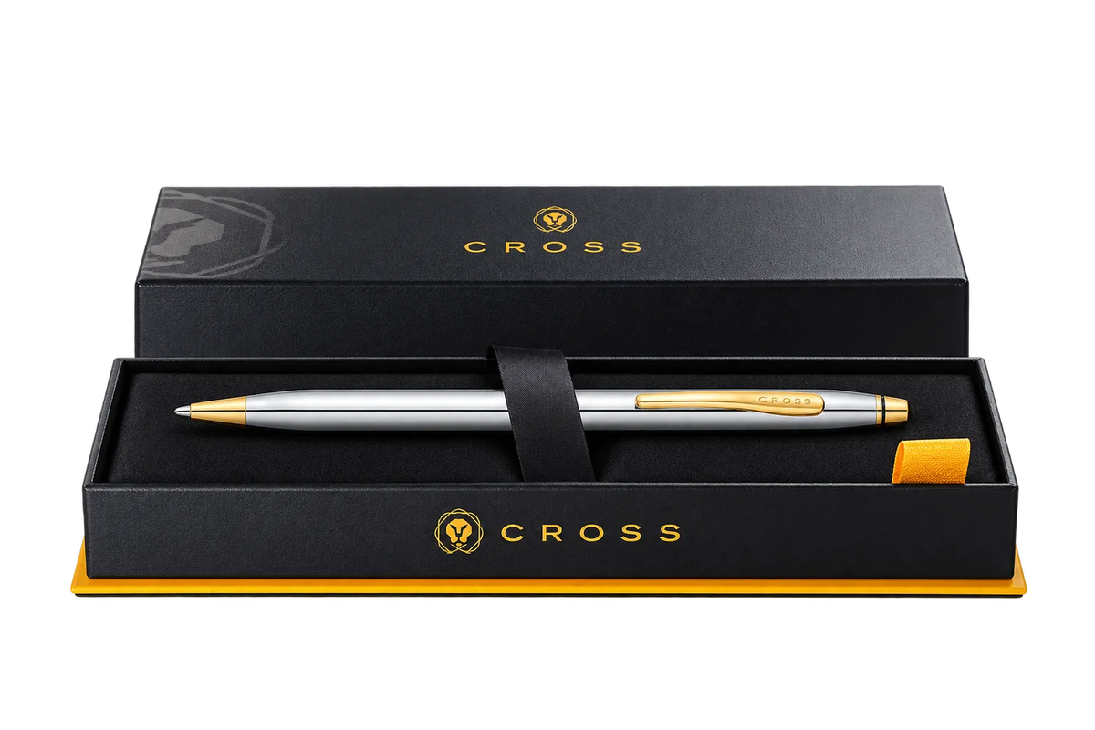 A silver and gold Cross pen presented in an open black gift box with a black strap, on a clean white background.